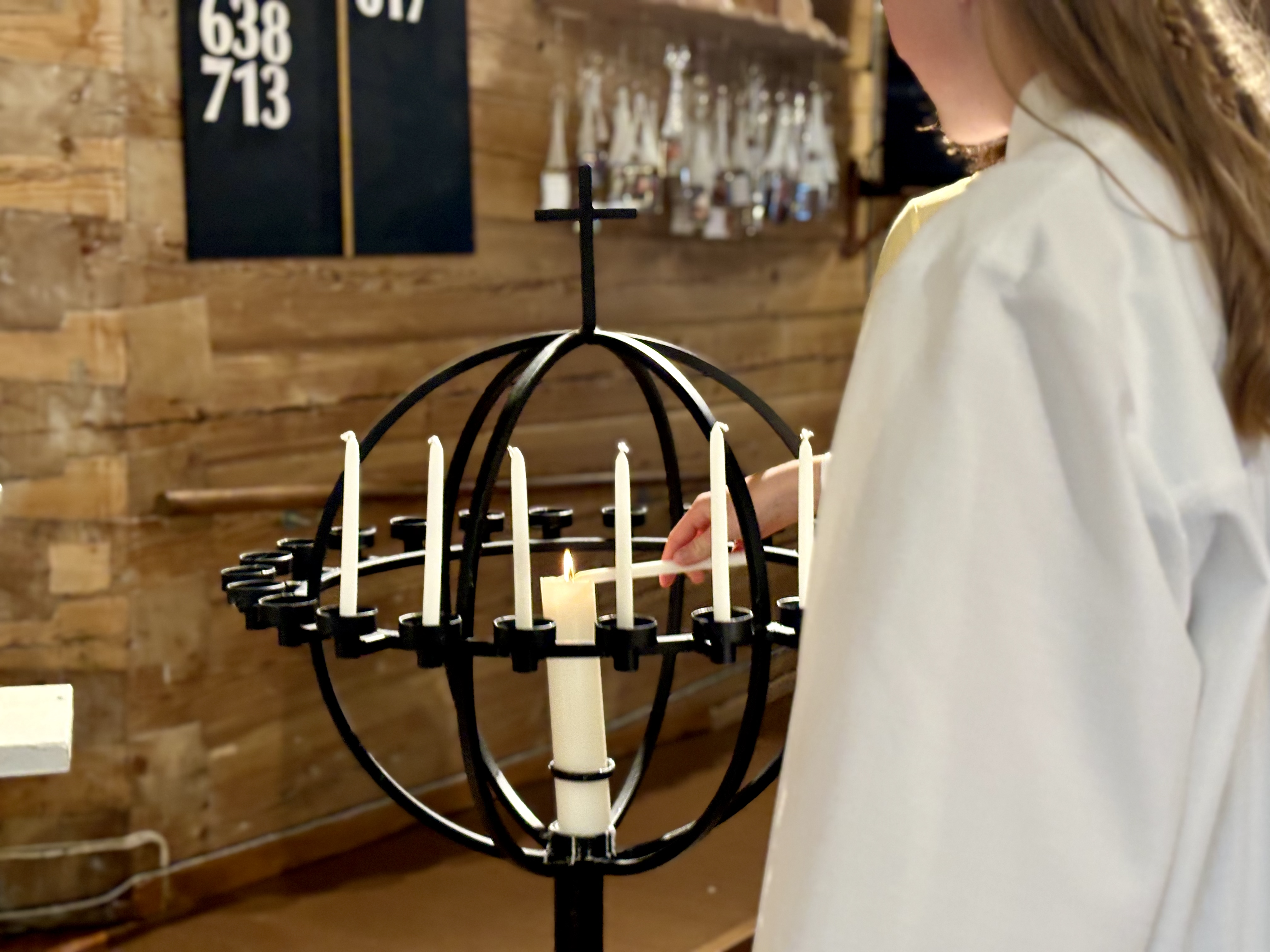 Konfirmant tenner lys i lysglobe