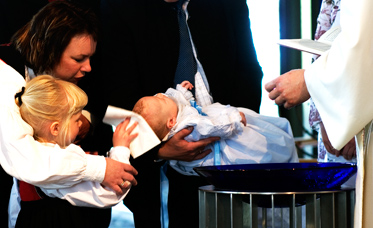 Bilde av et barn som blir døpt